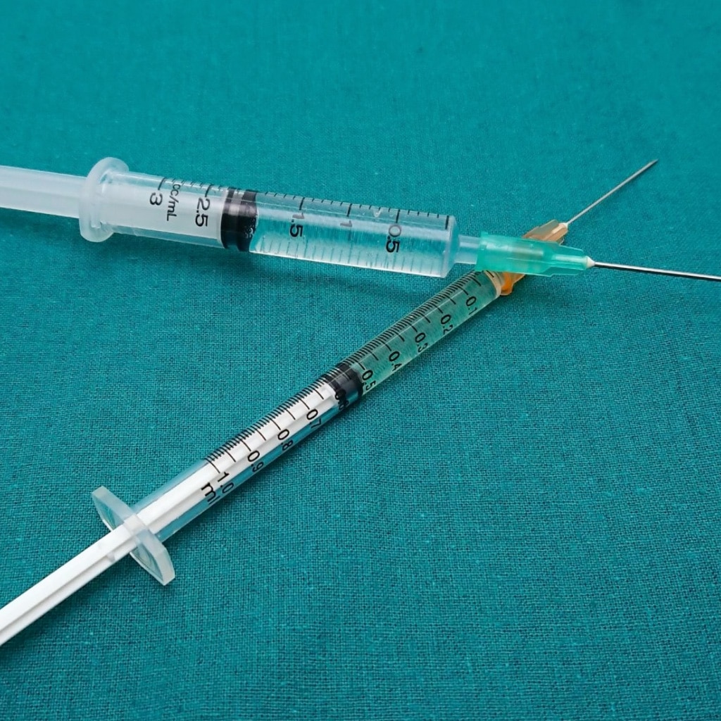 Picture of two syringes on a green background. Regulatory Requirements For Injectable Pharmaceuticals. Pyrogenic contamination. Visible particulate matter