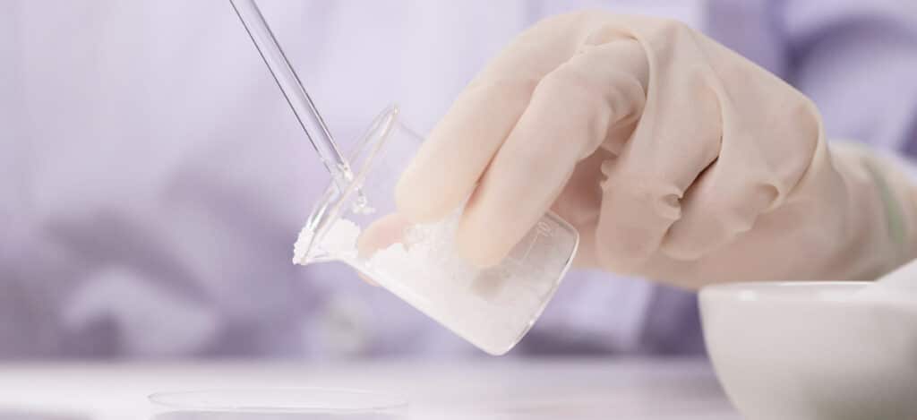Picture of a technician hand holding a flask with viscous parenteral product inside of it. How do you calculate Newtonian viscosity. Why is viscosity important for parenteral products. What are Newtonian fluids. Newton law of viscous flow. How do you calculate viscosity using a capillary viscometer