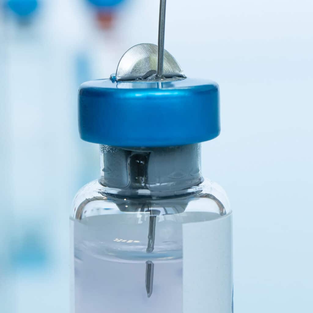 Close picture of syringe inside of a vial. Functionality testing for plastics. Testing for plastics used in injectables. Elastomeric packaging used in injectables. Plastic suitability for medical product packaging. Procedure for functionality testing. Acceptance criteria of functionaility testing